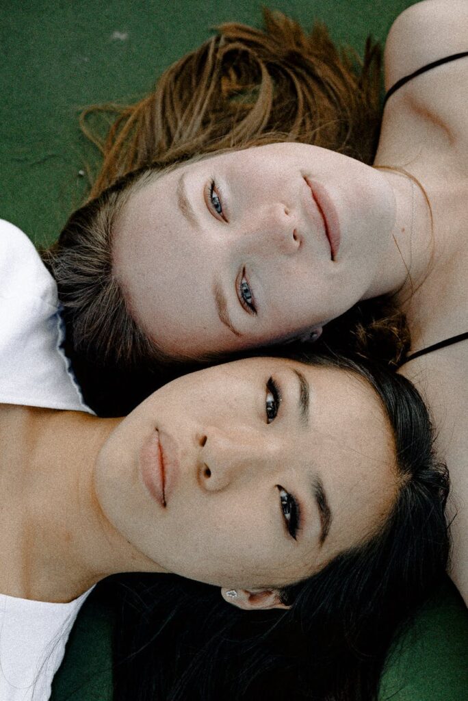 women lying on green surface